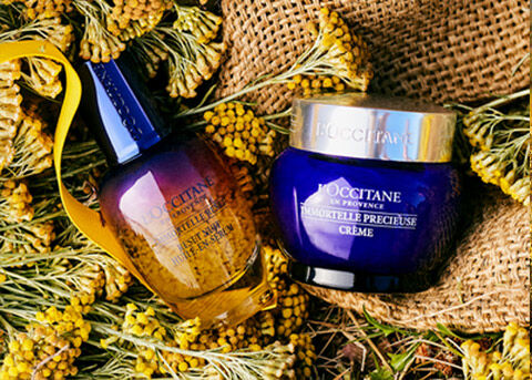 immortelle reset serum and precious cream lying in sack of immortelle flowers